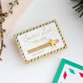 A gold-colored pin shaped like a Christmas list. The list has a slider that can be moved between "NAUGHTY" and "NICE." A star is placed on the slider.
