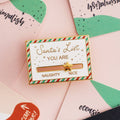 A gold-colored pin shaped like a Christmas list. The list has a slider that can be moved between "NAUGHTY" and "NICE." A star is placed on the slider.