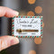 A gold-colored pin shaped like a Christmas list. The list has a slider that can be moved between 