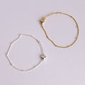 Gold and silver bracelets on a light gray background