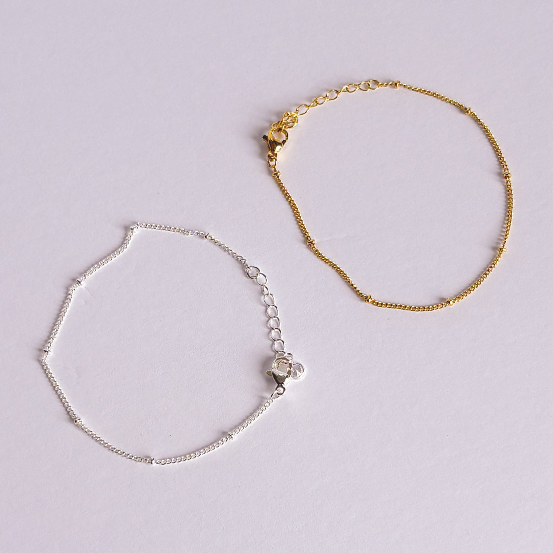 Gold and silver bracelets on a light gray background