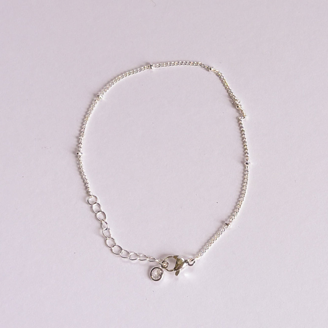 Silver bracelet on a light gray background