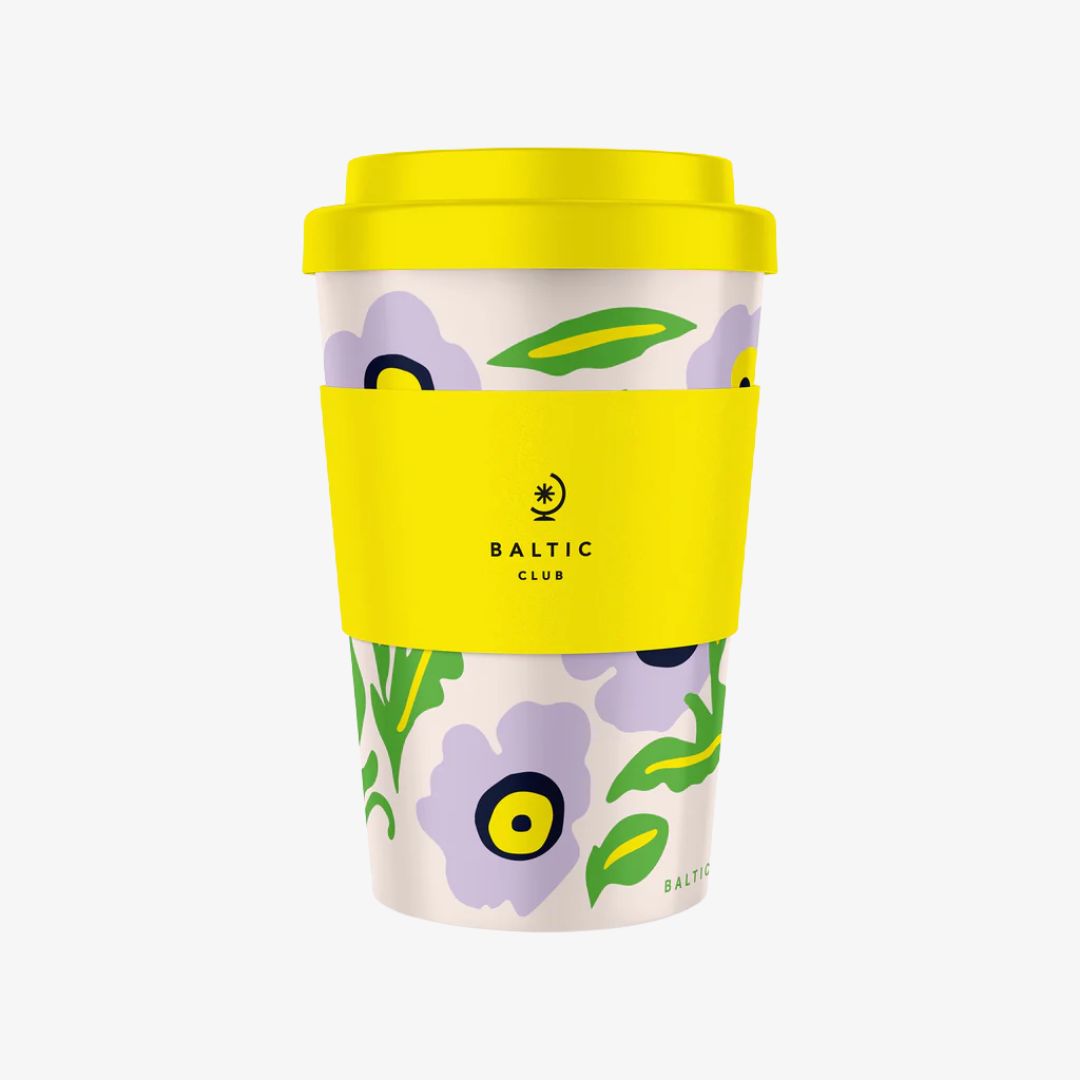 Reusable coffee cup with floral design and yellow lid on a white background