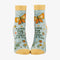 A pair of light blue ankle socks with yellow cuffs and toes. The socks feature an orange butterfly at the top and various small flowers and butterflies scattered across. Text on the socks reads 
