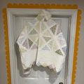 Quilted wall hanging with geometric pattern on a white door