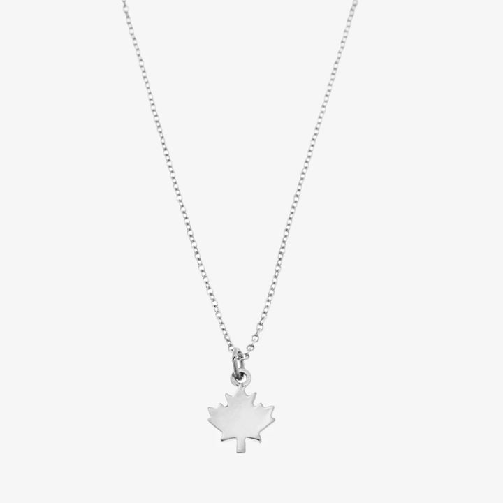 A silver necklace with a maple leaf pendant.