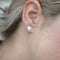 A pair of silver maple leaf stud earrings.