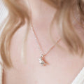 A silver bird pendant on a silver plated chain.