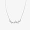 A silver necklace with several rectangular-shaped crystals on a pink card with the brand name 