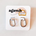A pair of Agaveh Girl Silver Layla Hoops, featuring a chunky, rounded oval design, displayed on a branded card with the text 'agaveh girl,' against a textured background. The earrings are minimalist and modern, available in Ottawa, Ontario, Canada.