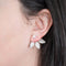 A pair of silver leaf earrings with detachable ear jackets. The earrings feature three overlapping leaf-shaped designs with a small pearl in the center of each leaf. 