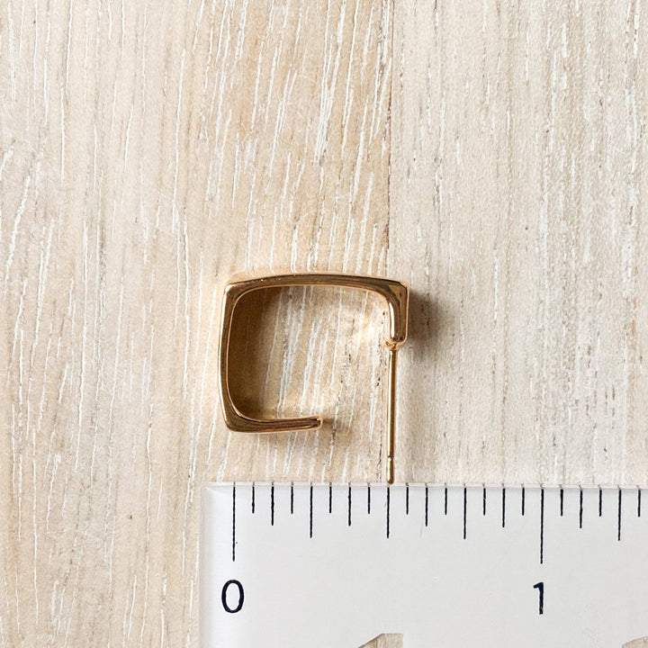 A pair of silver squared hoop earrings, featuring a chunky, geometric square design, displayed on a white, textured surface. The earrings are modern and minimalist, available in Ottawa, Ontario, Canada.