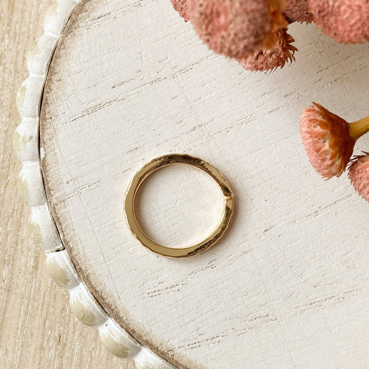 A gold-plated ring with a textured, hammered surface. The ring is gold plated and adjustable.