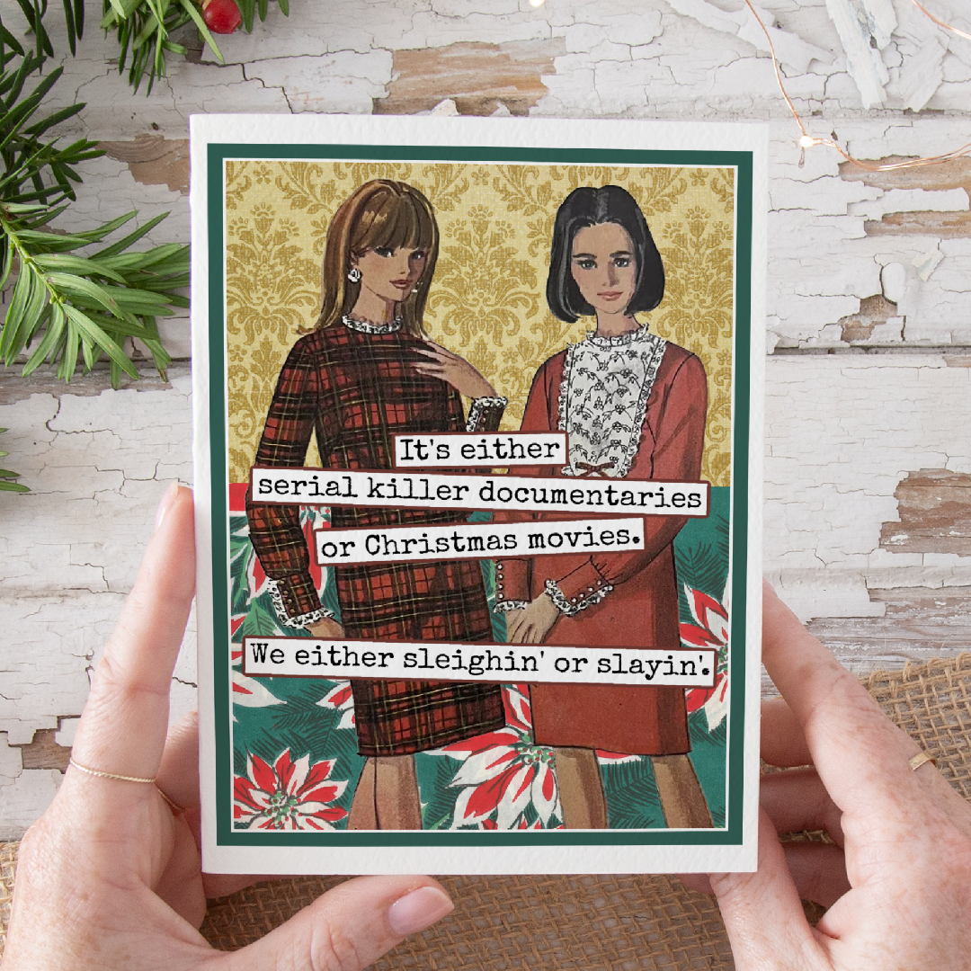 Card with two women and text about serial killer documentaries and Christmas movies, held by hands on a rustic background.