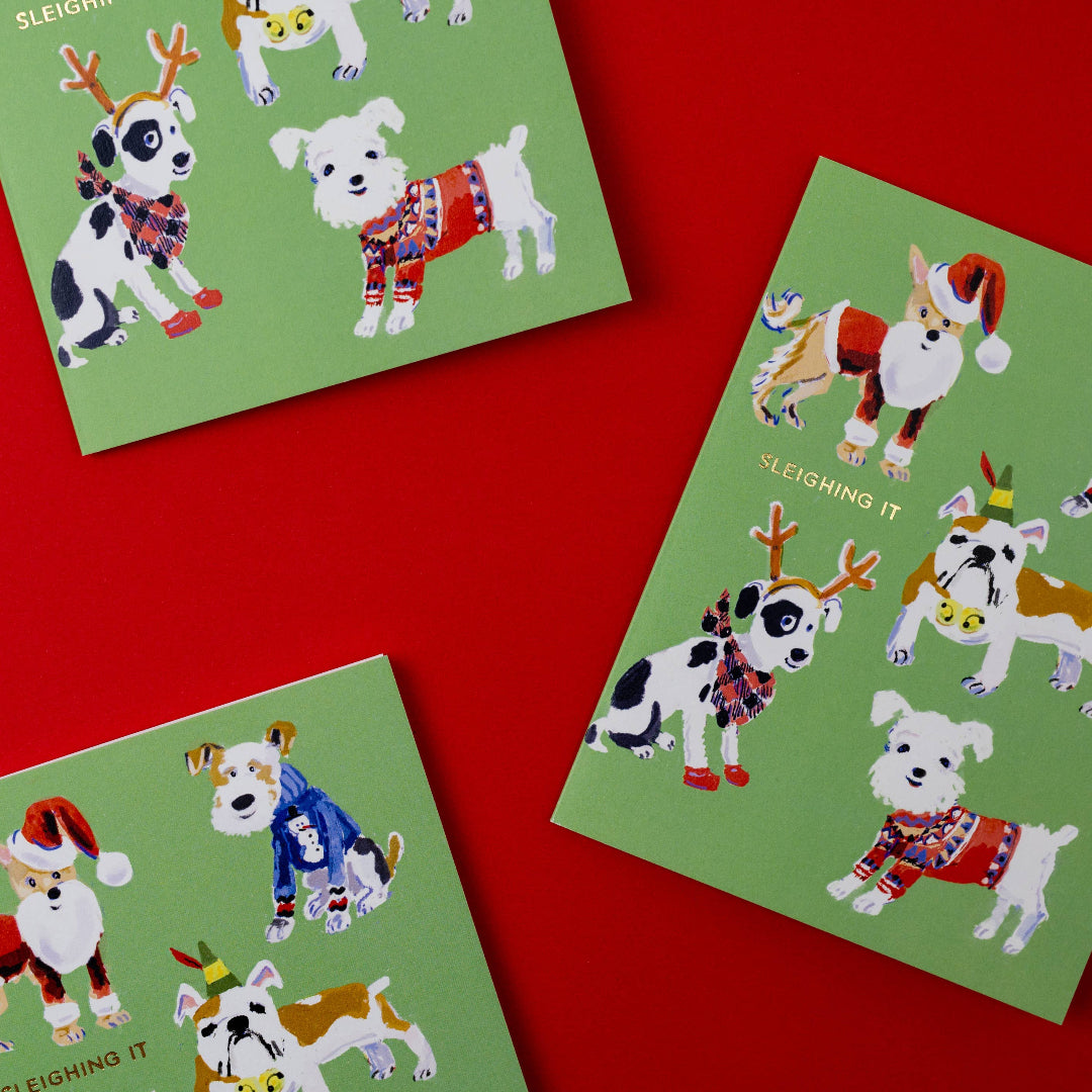 Three green greeting cards with festive dog illustrations on a red background