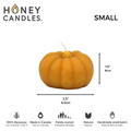 A small, pumpkin-shaped beeswax candle. The candle is orange with detailed ridges and a wick in the center.