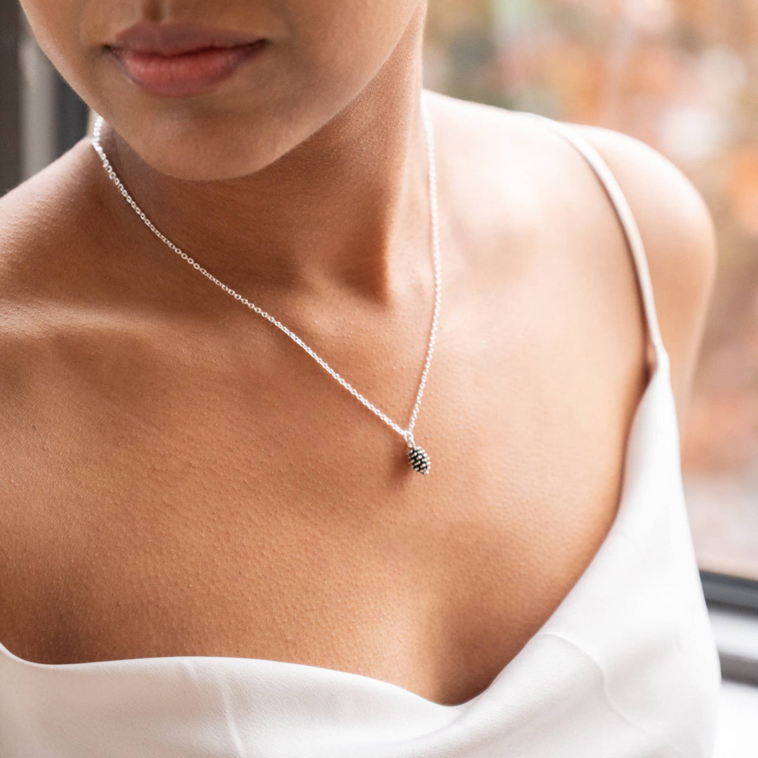 Close-up of a necklace with a small pendant on a blurred background