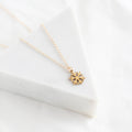 Gold snowflake necklace on a white fabric background