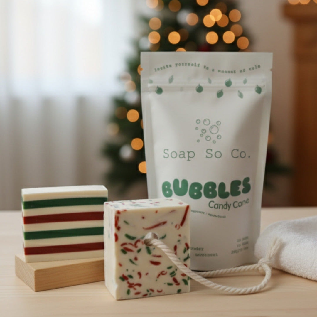 Soap So Co. bubble bag with two soap bars on a wooden surface, Christmas tree in the background