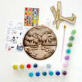 Wooden art project with paint supplies on a white background