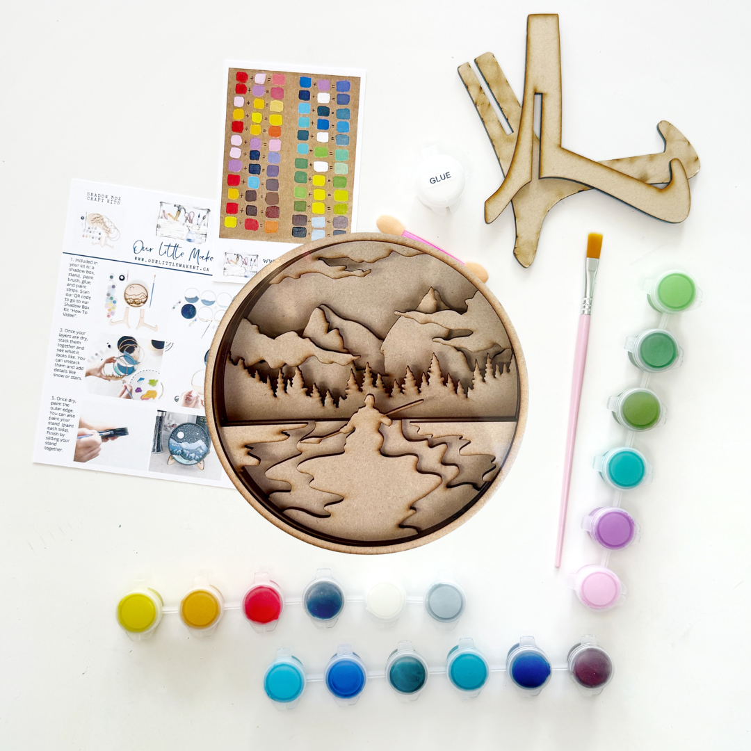 Wooden art project with paint supplies on a white background