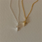 A set of silver and gold necklaces, each featuring a delicate chain and a minimalist four-pointed star or starfish-like pendant, resembling a sparkle emoji, displayed on a light surface. These celestial necklaces are available in Ottawa, Ontario, Canada.