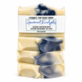 Four stacked bars of Carrot Top Soap Shop Spearmint Eucalyptus luxury artisan soap, featuring a creamy beige base with dark blue-gray swirls, wrapped in a white paper label.