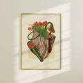 Framed artwork of a still life with flowers and a bag on a beige wall.