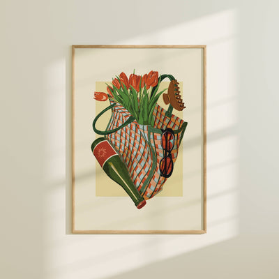Framed artwork of a still life with flowers and a bag on a beige wall.