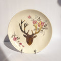 Decorative plate with a deer head and floral design on a white background