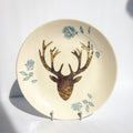 Decorative plate with deer head and floral design on a white background