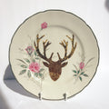 Decorative plate with deer head and floral design on a white background