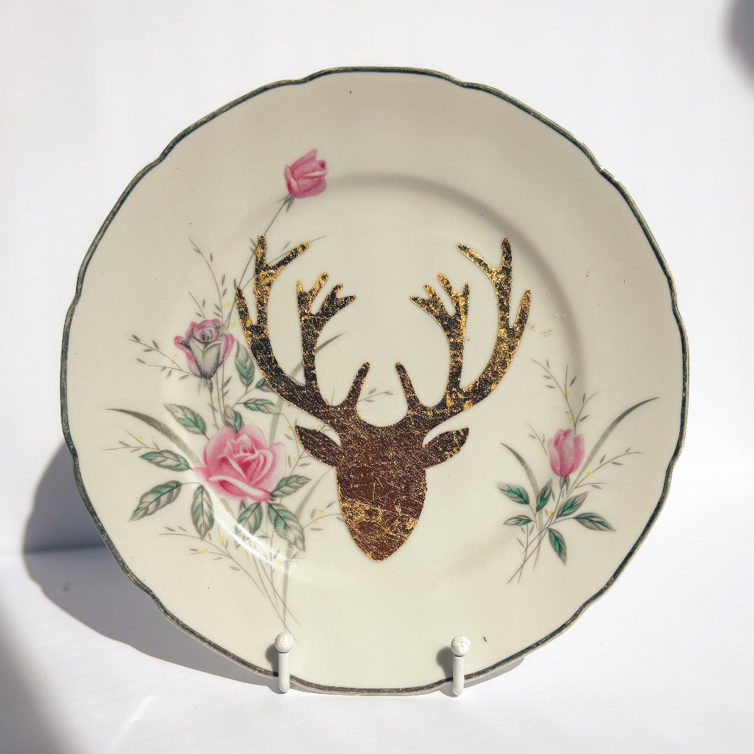 Decorative plate with deer head and floral design on a white background