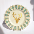 Decorative plate with gold deer head design and floral patterns on a white background