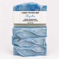 Three stacked bars of blue marbled artisan soap with a white paper label that reads 'CARROT TOP SOAP SHOP Staycation LUXURY ARTISAN SOAP', on a clean white background.