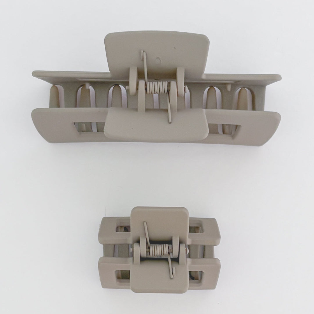 Two beige hair clamps on a white background