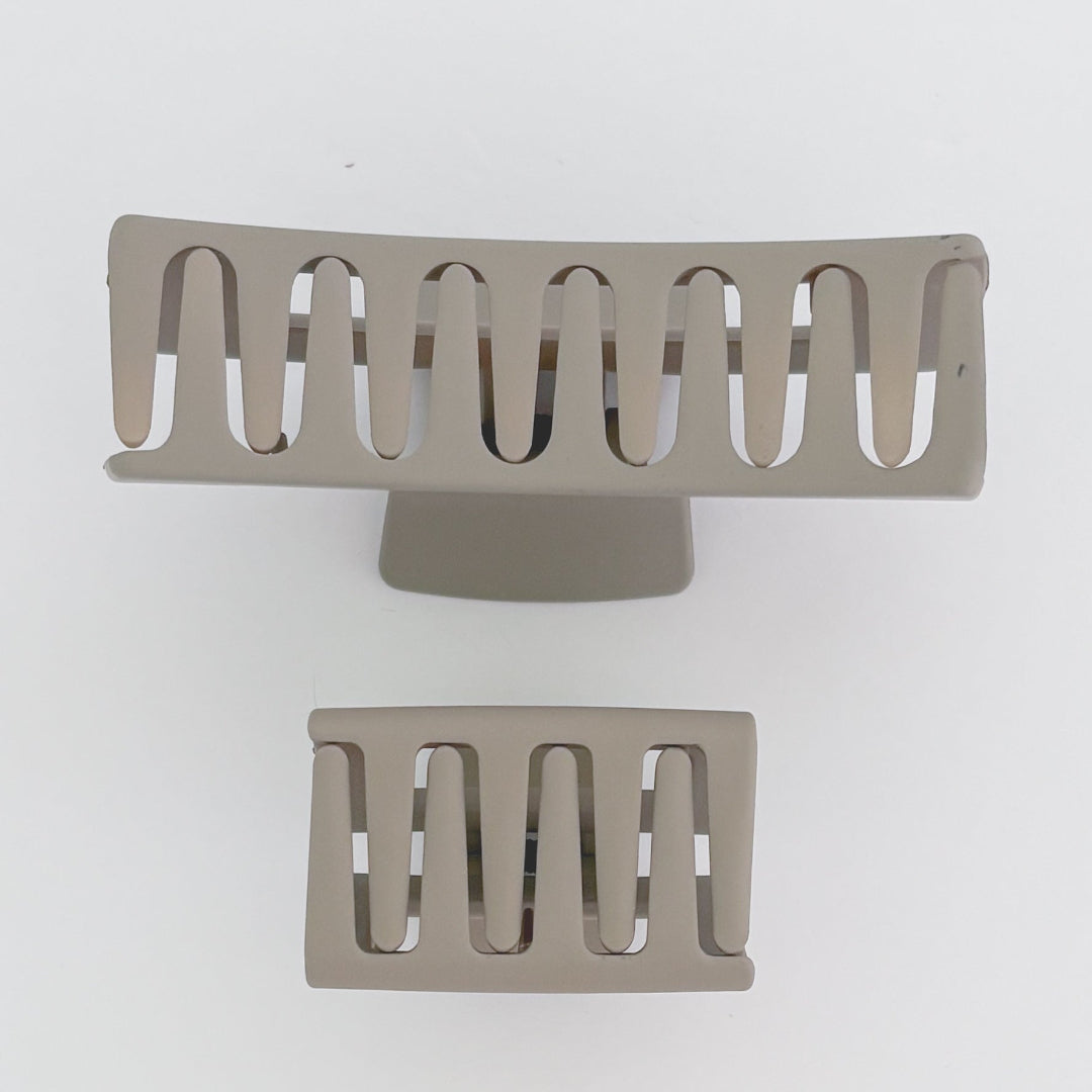 Two metallic hair clips on a white background