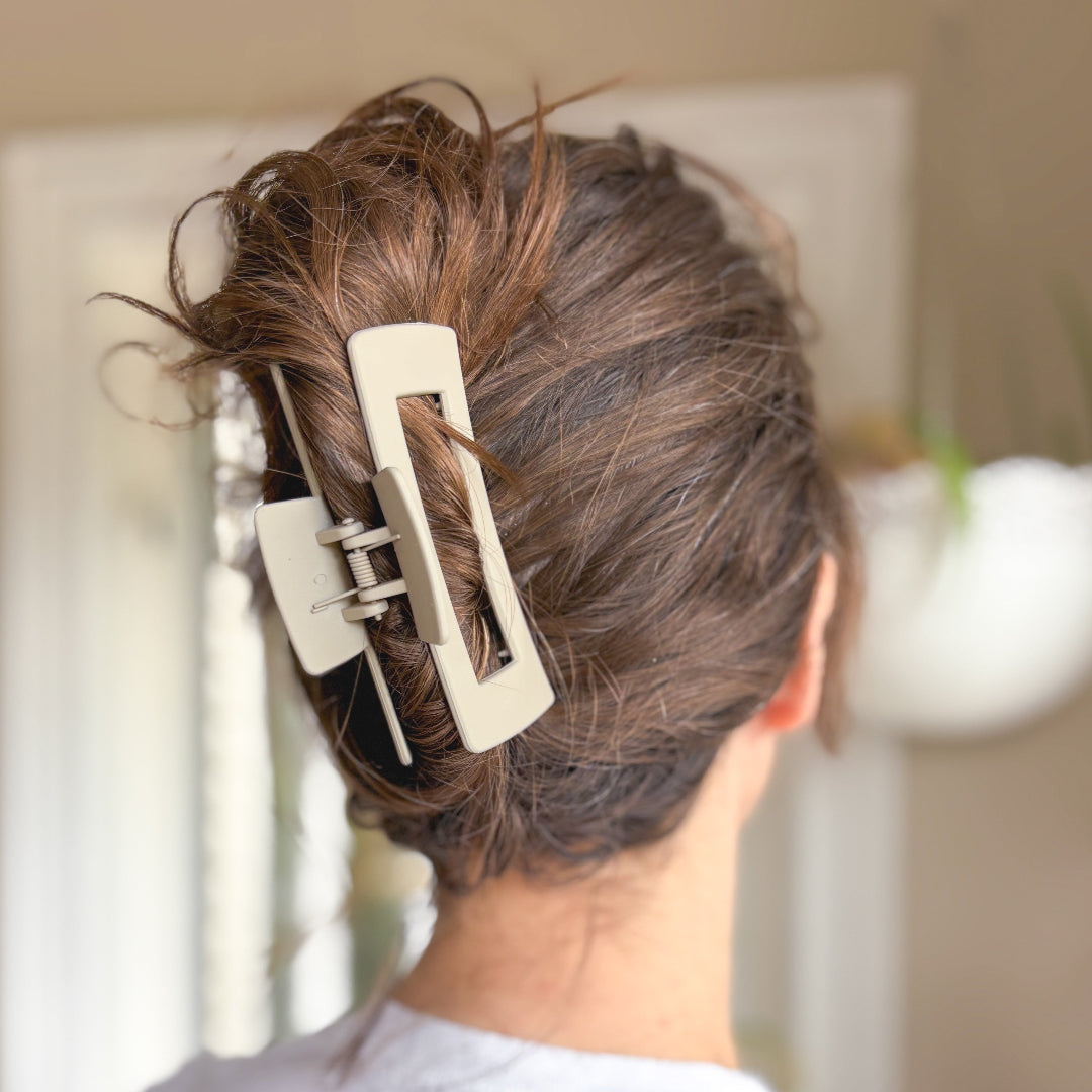 Person with a hair clip in their hair against a blurred background
