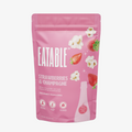 Pink package of Eatable strawberries and champagne popcorn on a pink background