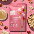 Eatable strawberries and champagne popcorn package on a pink background with strawberries, popcorn, and a drink.