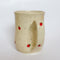 A handmade ceramic mug by Valerie Daoust Ceramics, featuring hand-painted red strawberries on a speckled cream background, displayed on a light gray background. The mug has a large, rounded handle, a speckled texture, and is made in Mississippi Mills, Ontario, Canada.