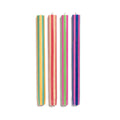 Four slim striped candles standing vertically on a plain white background. From left to right, the candle colors are yellow and green, orange and pink, light green and pink, and blue and purple.