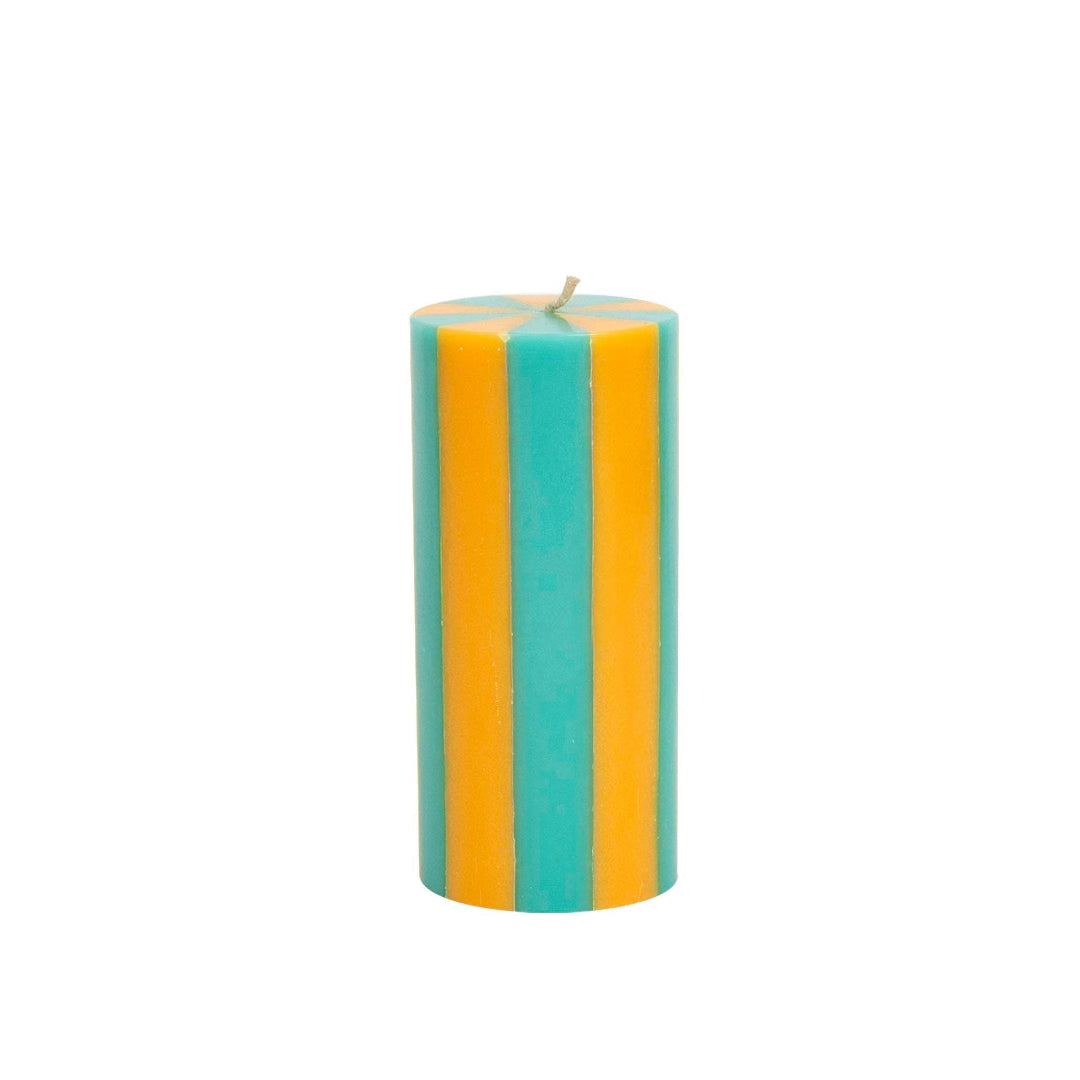 Striped teal and yellow candle on a white background