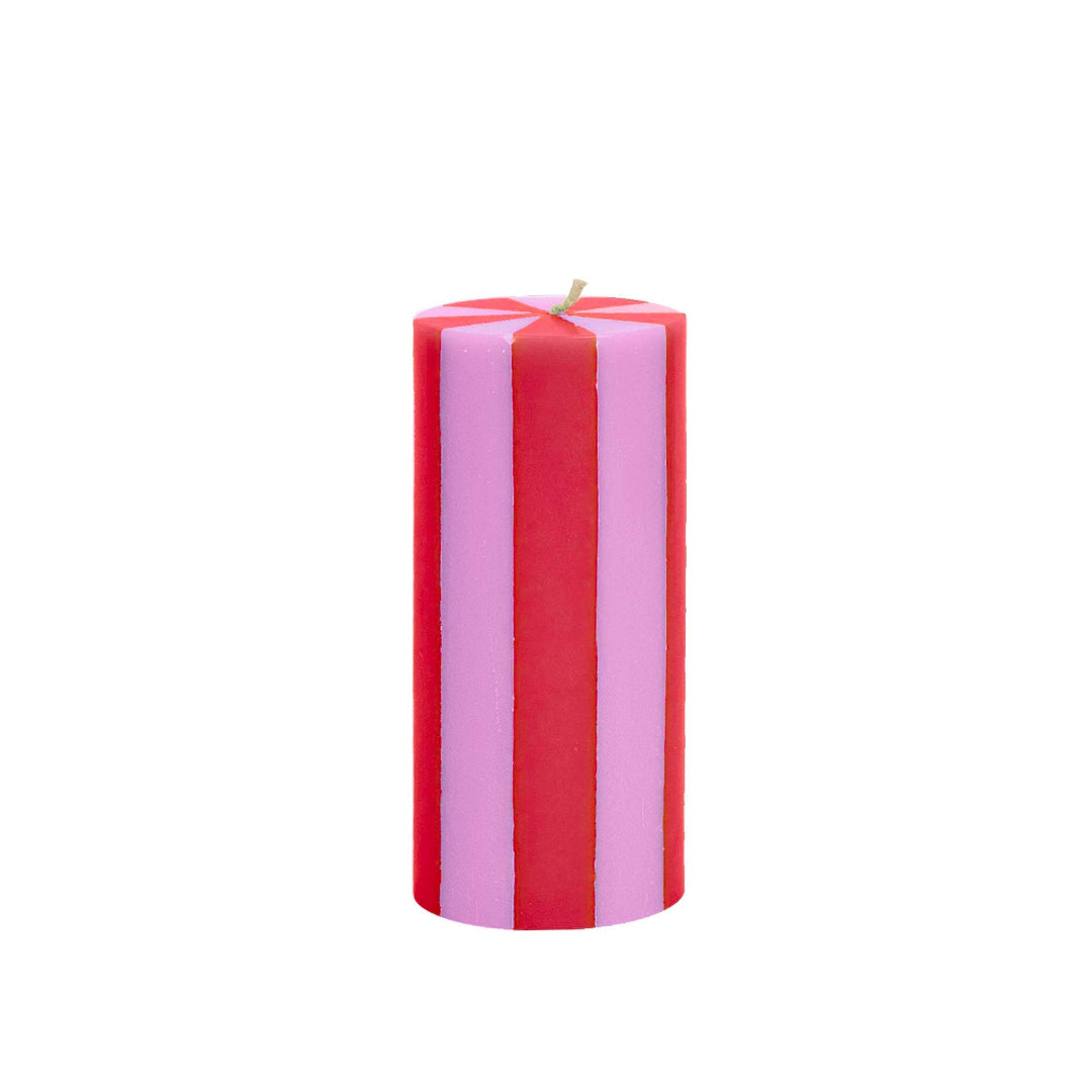 Striped red and pink candle on a white background