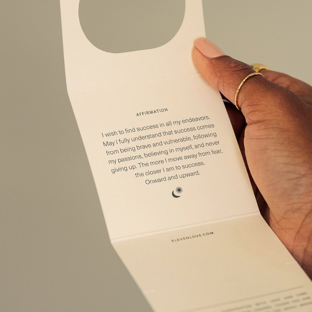 Hand holding a paper card with text and a circular cutout.