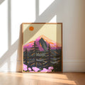 A framed art print of a stylized mountain landscape with pine trees and pink flowers, leaning against a white wall on a light wood floor in a sunlit room.