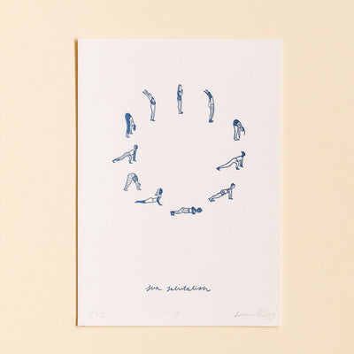 Framed artwork with blue line drawings of yoga poses on a white background