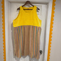 Yellow and brown striped dress on a hanger against a white door with decorative yellow border.