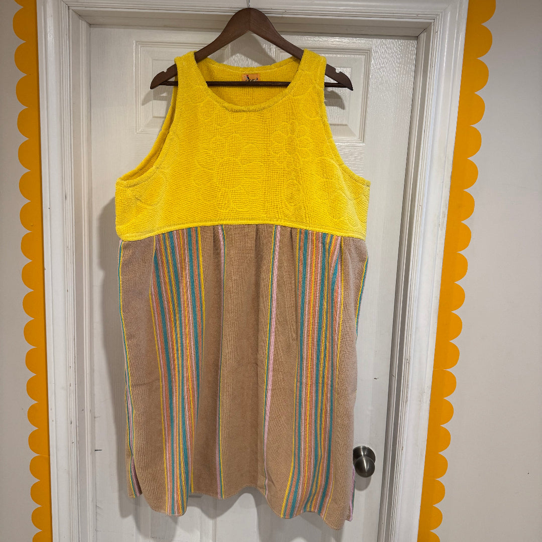 Yellow and brown striped dress on a hanger against a white door with decorative yellow border.