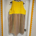 Yellow top and brown striped dress on a hanger against a white door with orange trim.